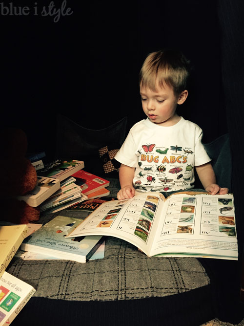 Reading in his play tent