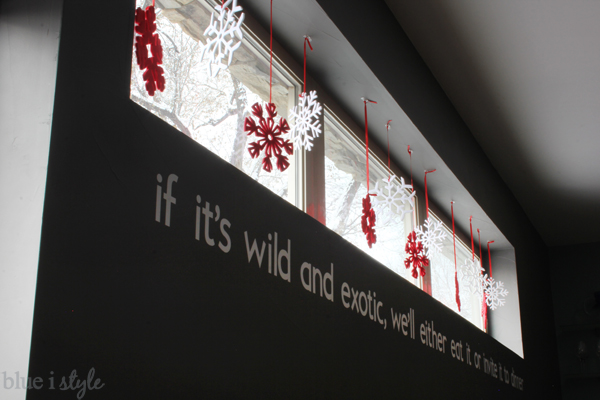 Hang snowflake ornaments in a window for a fun indoor snowstorm Snowflake ornaments in window Christmas winter display