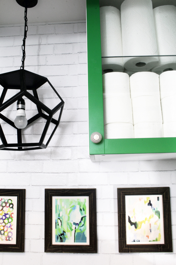 Geometric light fixture hanging between cabinets in laundry room