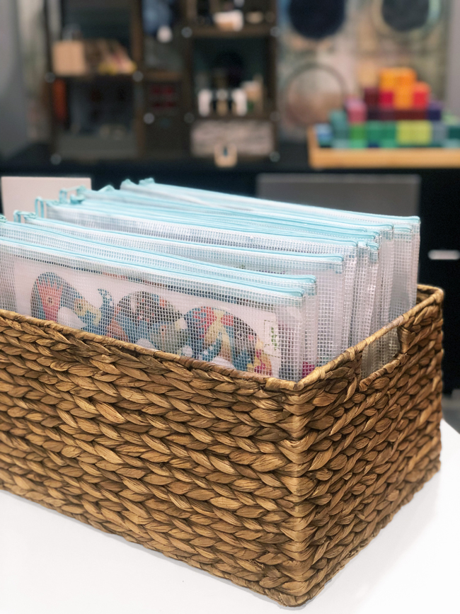 store puzzles in zippered pouches in a wicker basket