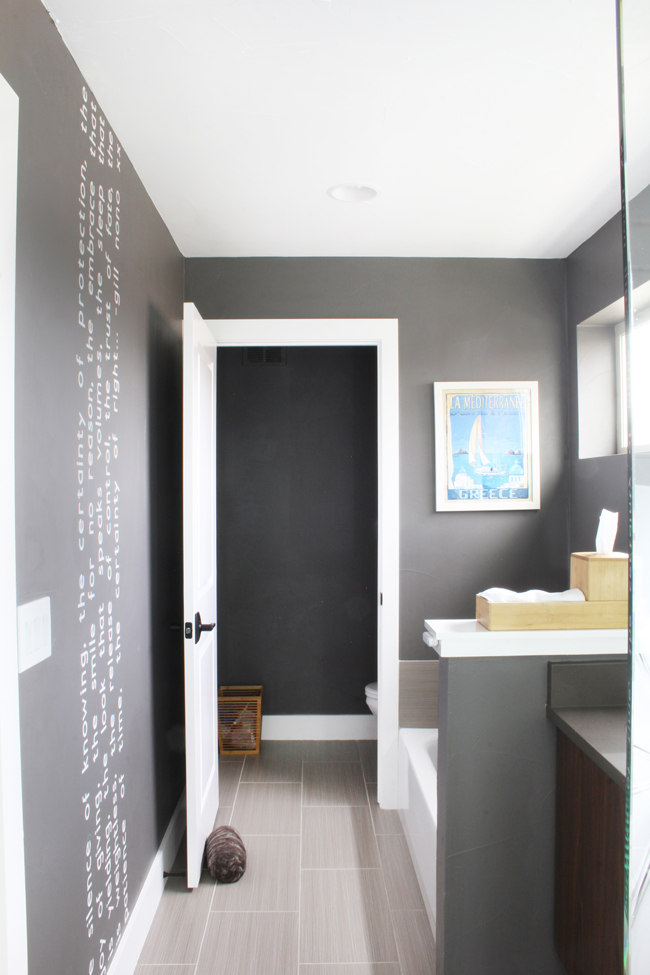 white vertical wall quote floor to ceiling on dark gray bathroom wall