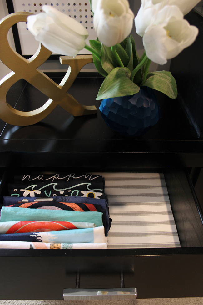 dresser drawer lined with gray and white striped fabric shelf liner