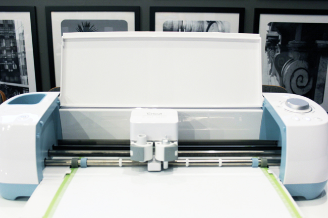 Cricut Explore Air machine cutting white vinyl on green mat