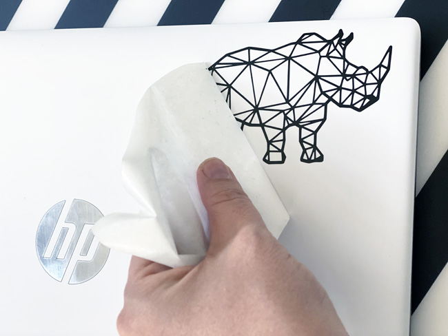 Adding a vinyl rhino sticker to a laptop 