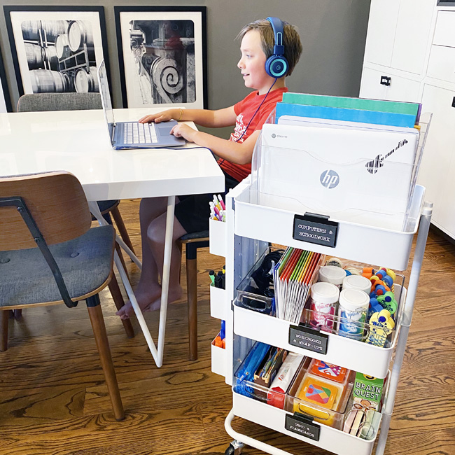 Rolling cart with distance learning school supplies by the kitchen table